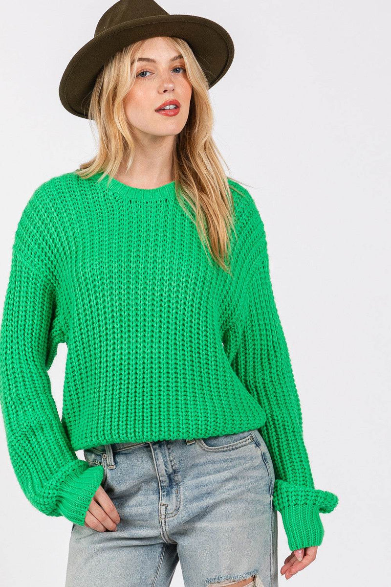 SAGE + FIG Round Neck Drop Shoulder Sweater in green, styled with jeans and a hat.