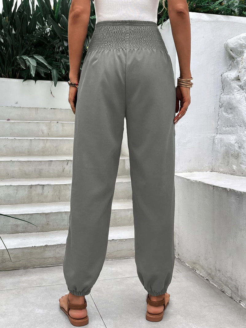 Smocked High Rise Joggers with Pockets in gray, featuring an elastic waistband and cuffed ankles.