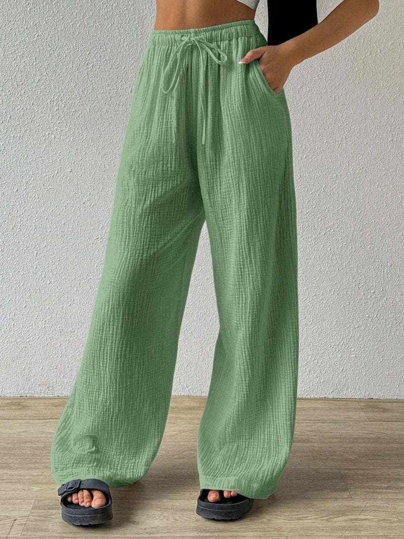 Green drawstring wide leg pants made of 100% polyester.