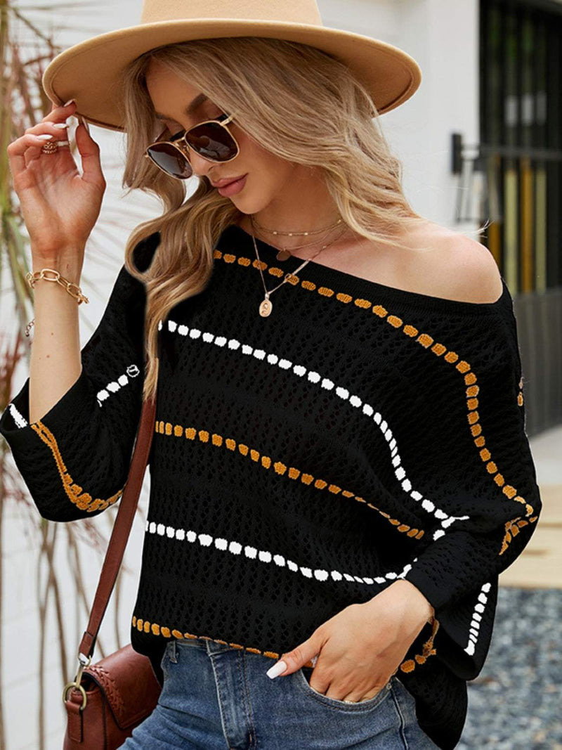 Woman wearing black eyelet striped round neck knit top with sunglasses and hat.
