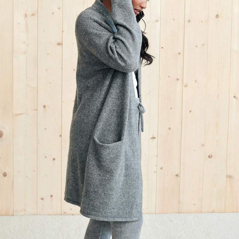 Woman wearing grey open front long sleeve cardigan with pockets.