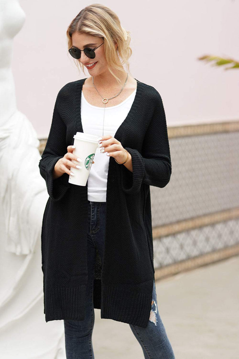 Woman wearing black open front long sleeve cardigan with sunglasses and holding a coffee cup.