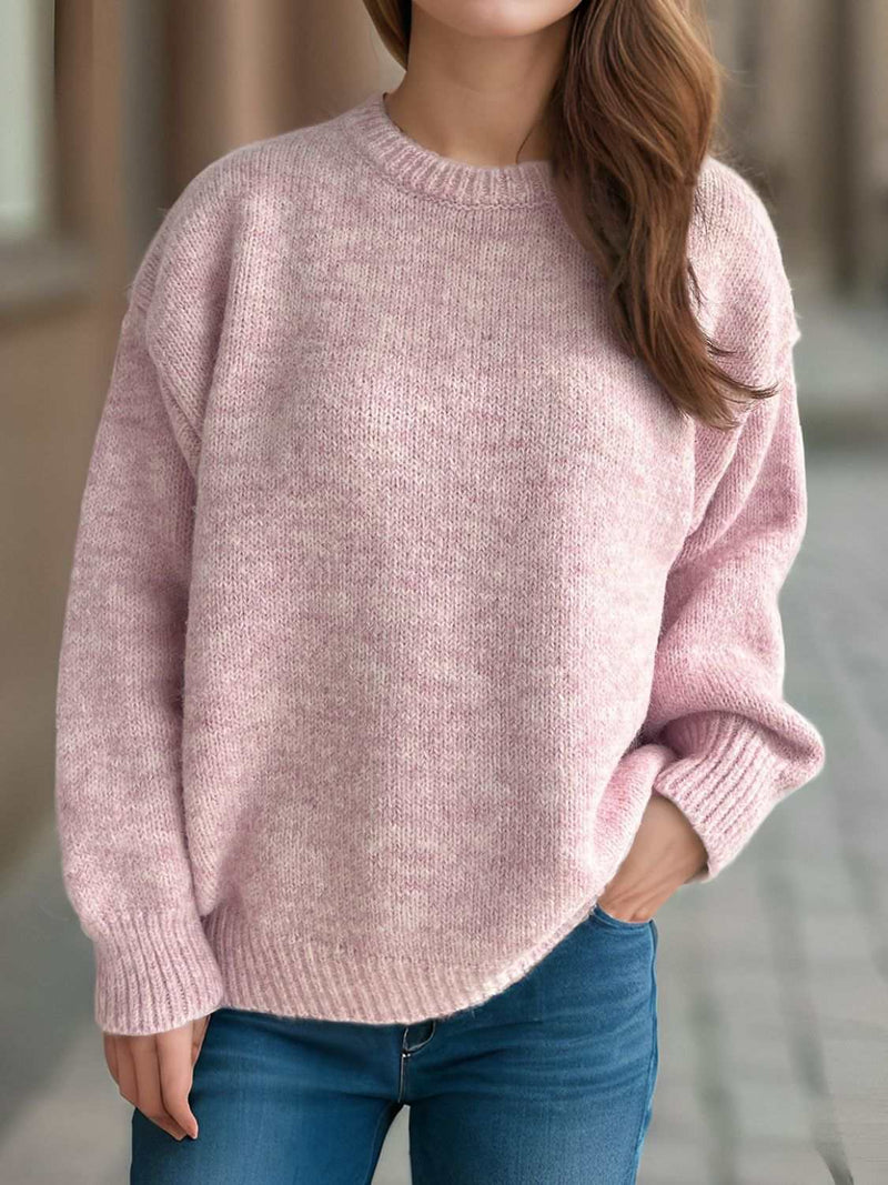 Round neck long sleeve sweater in soft pink worn casually with jeans.