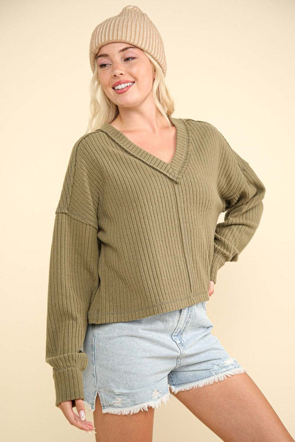 V-neck ribbed knit top with long sleeves and exposed seam.