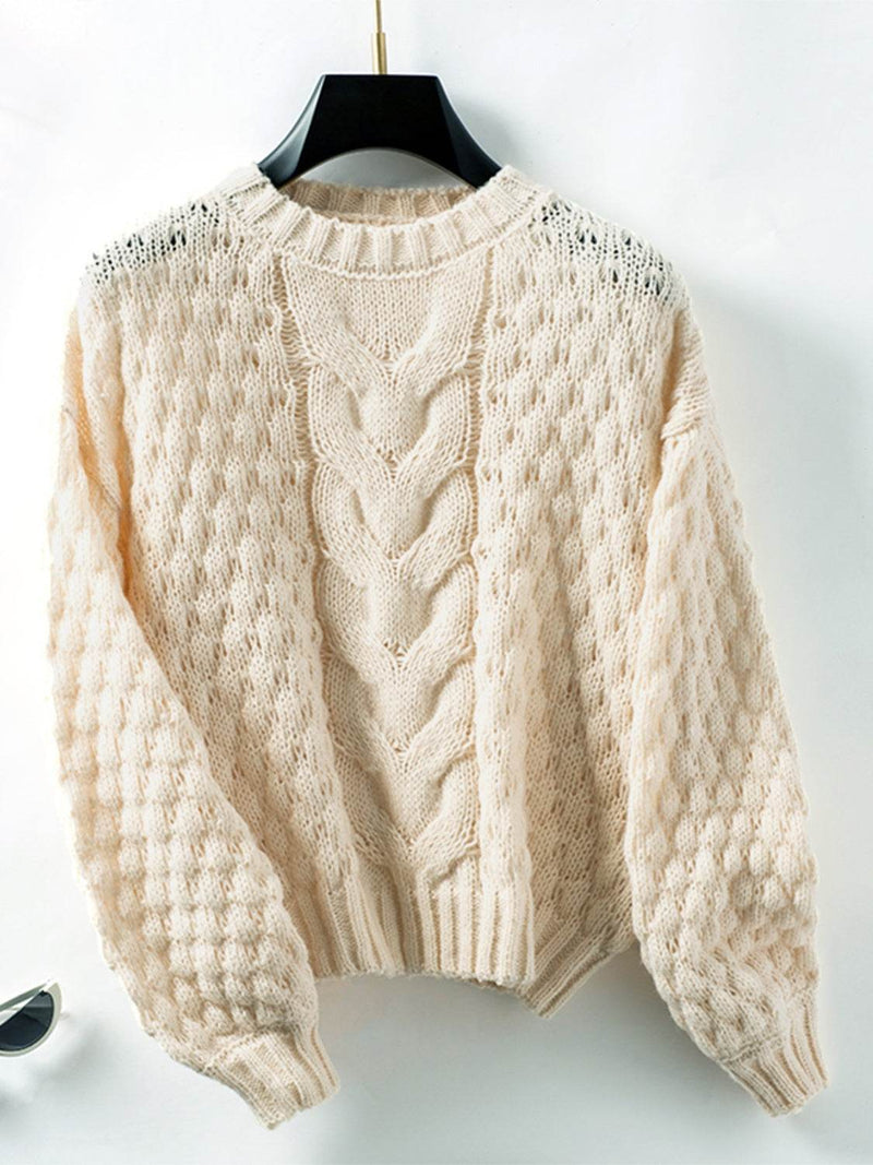 Cable-knit round neck long sleeve sweater in cream color on hanger.