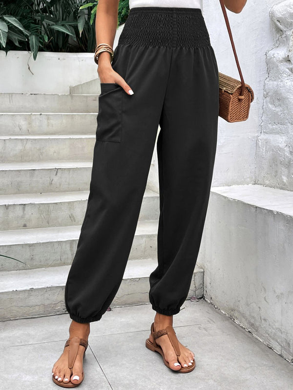 Smocked high rise joggers with pockets in black, casual style, worn outdoors.