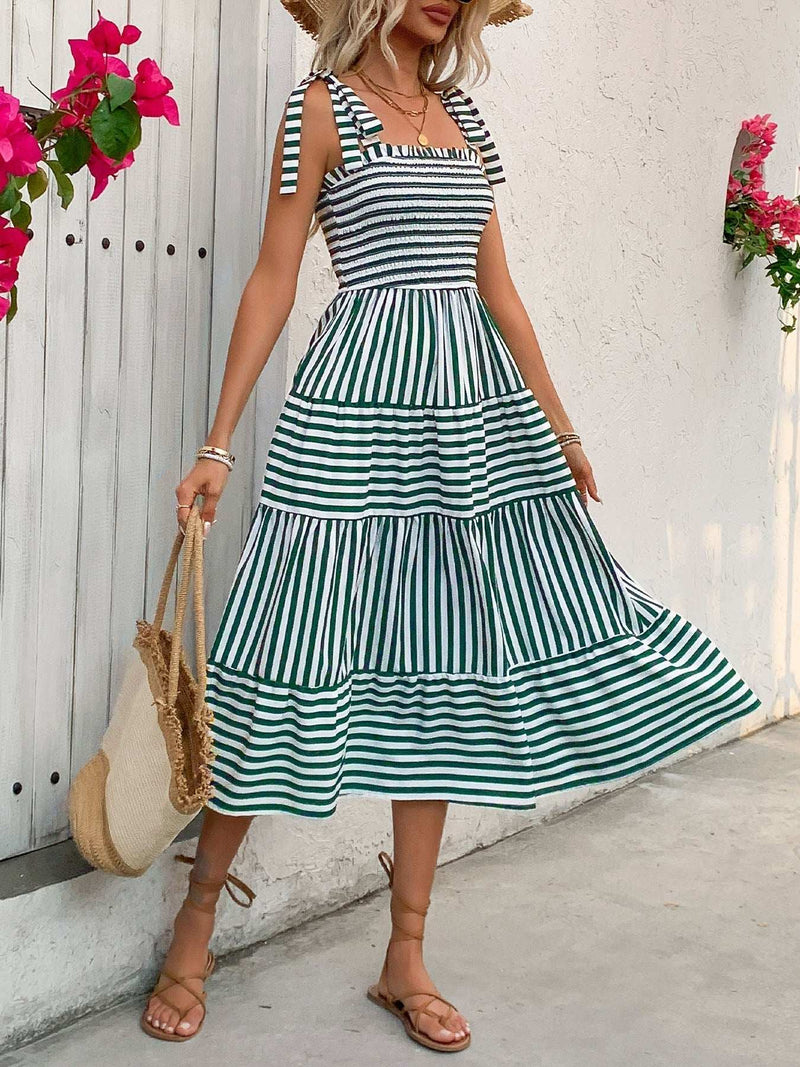 Perfee Smocked Striped Square Neck Midi Dress with tie straps and tiered skirt, worn by a woman carrying a straw bag.