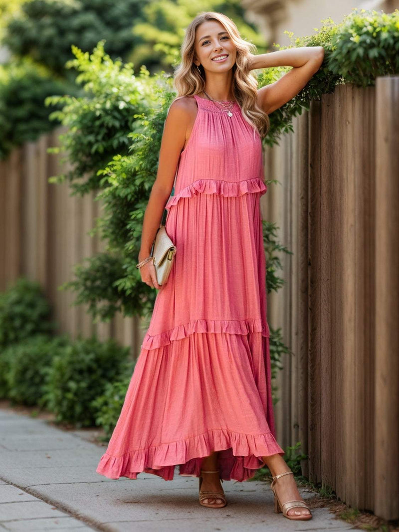 Ruffled sleeveless tiered maxi dress with pockets in pink, featuring high-low hem and smocked detail.