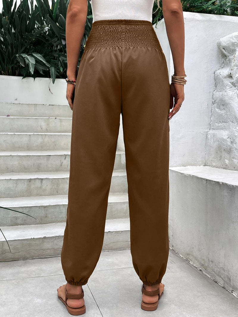 Smocked high rise joggers with pockets, opaque polyester-spandex blend.