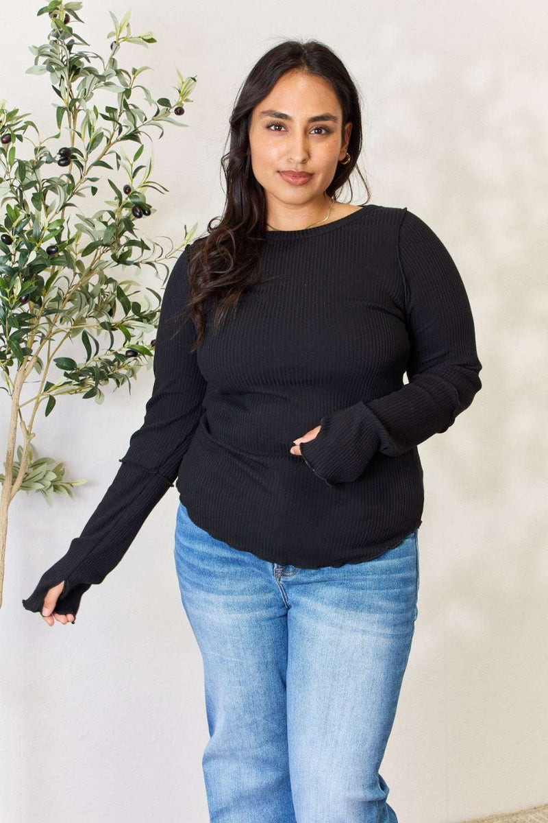 Culture Code Full Size Ribbed Round Neck Long Sleeve Top in black, worn by a model with long hair, paired with blue jeans.