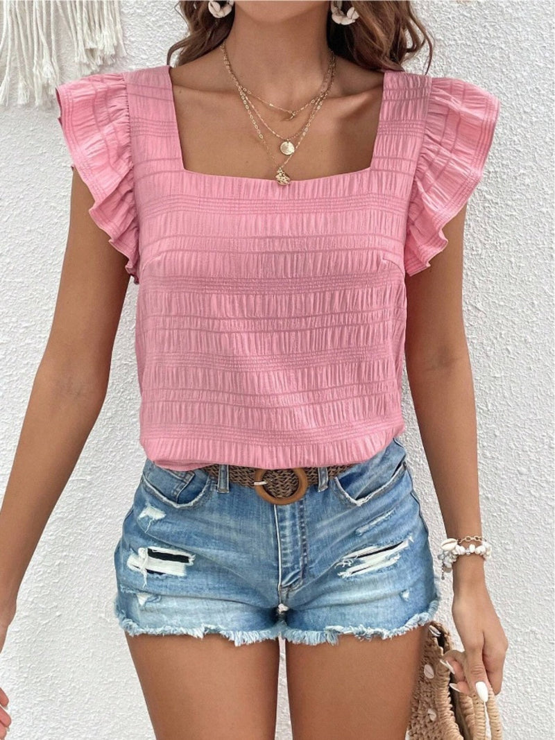 Ruffled square neck cap sleeve blouse in pink worn with denim shorts.