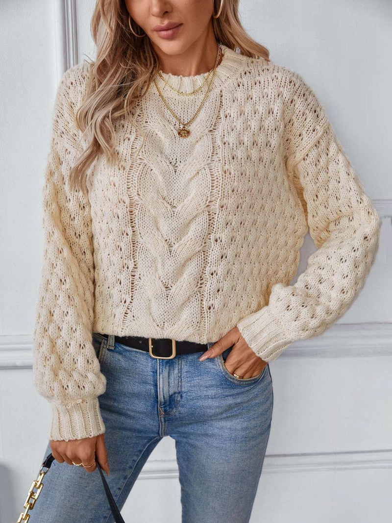 Cable-knit round neck long sleeve sweater in cream with jeans.