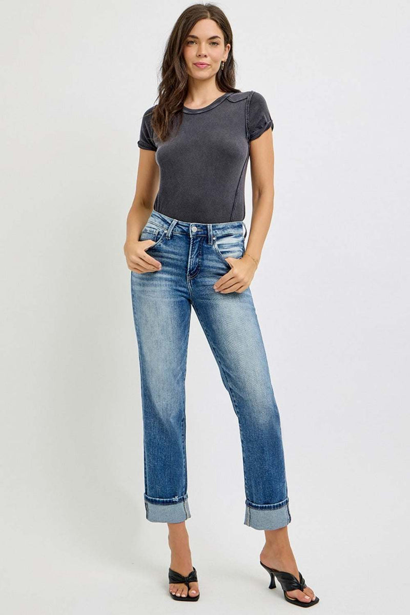 Woman wearing RISEN Full Size High Rise Crop Straight Roll Up Jeans with rolled hem and black heels.