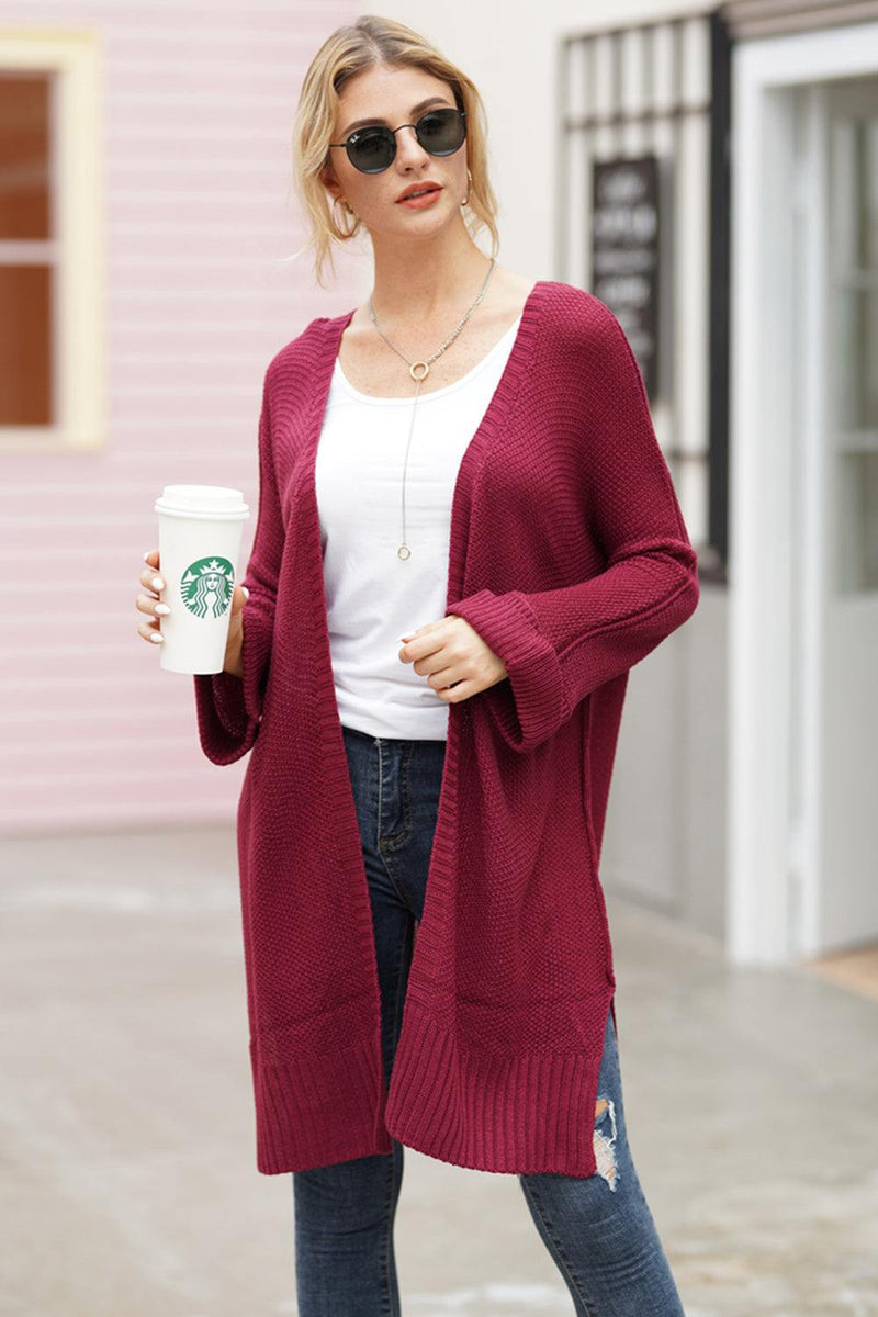 Woman wearing open front long sleeve cardigan in red with coffee cup.