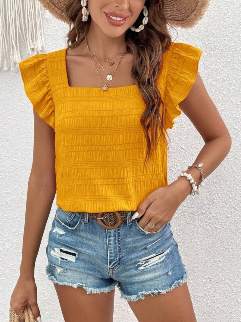 Ruffled square neck cap sleeve blouse in mustard yellow, styled with distressed denim shorts.