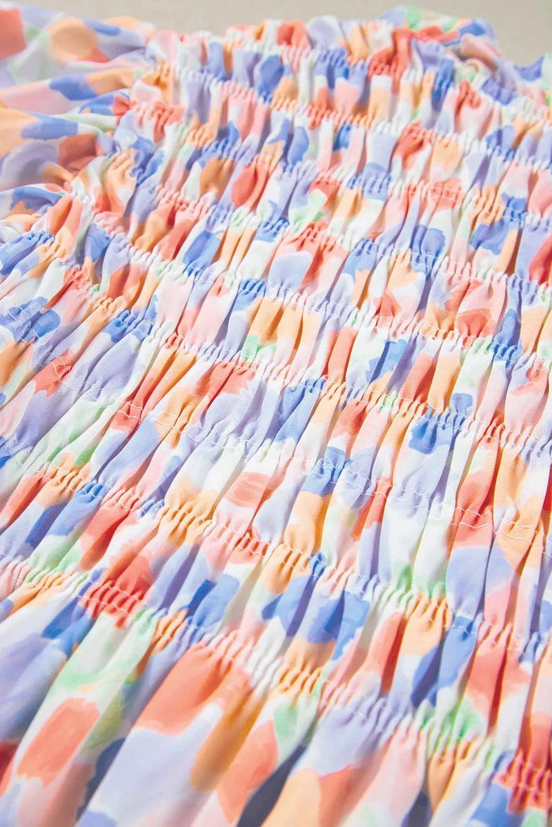 Colorful ruffled printed notched cap sleeve blouse in polyester fabric.