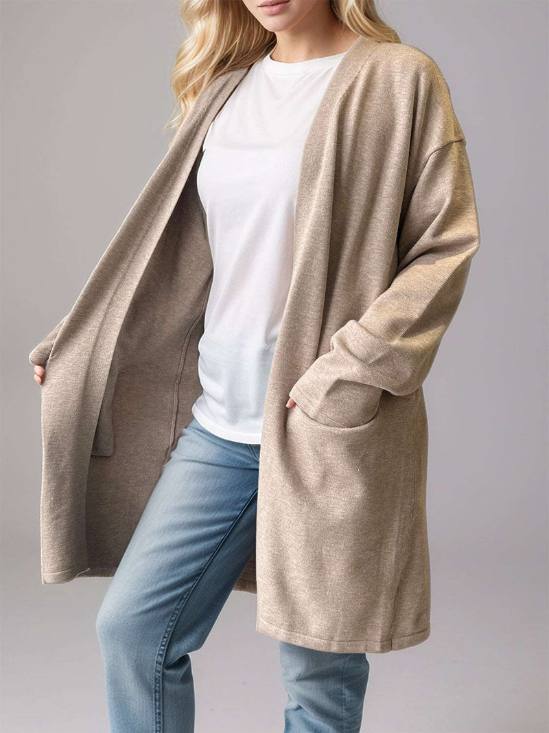 Open front long sleeve cardigan with pockets in beige, worn over a white top and jeans.