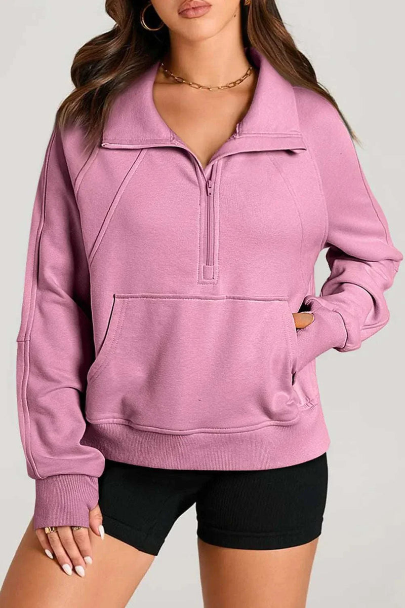 Pink half zip long sleeve sweatshirt with pocket, worn by model, showing comfort and style.