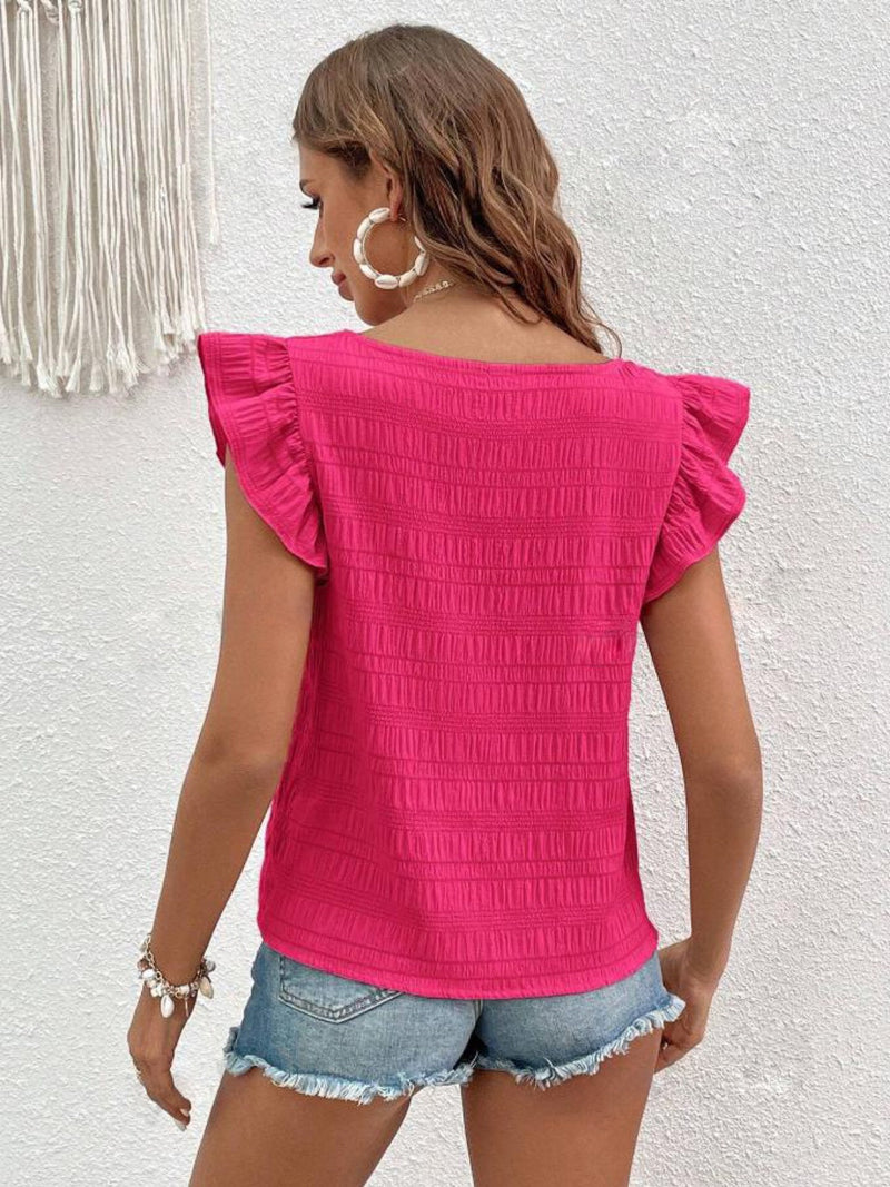 Pink ruffled square neck cap sleeve blouse worn with denim shorts.