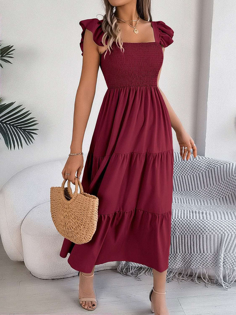 Smocked square neck cap sleeve midi dress in burgundy, styled with a woven handbag.