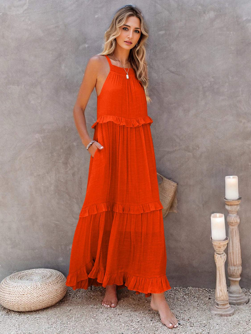 Woman wearing orange ruffled sleeveless tiered maxi dress with pockets, high-low hem, and smocked waist.