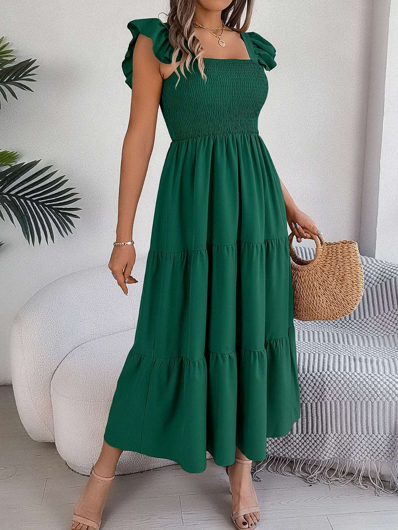 Woman wearing a green smocked square neck cap sleeve midi dress.