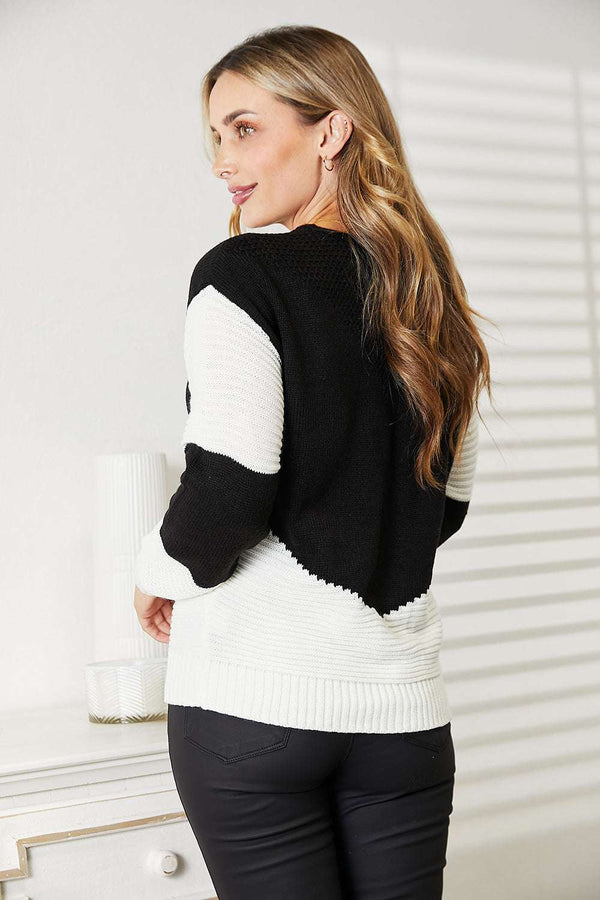 Two-tone openwork rib-knit sweater with round neckline and long sleeves.