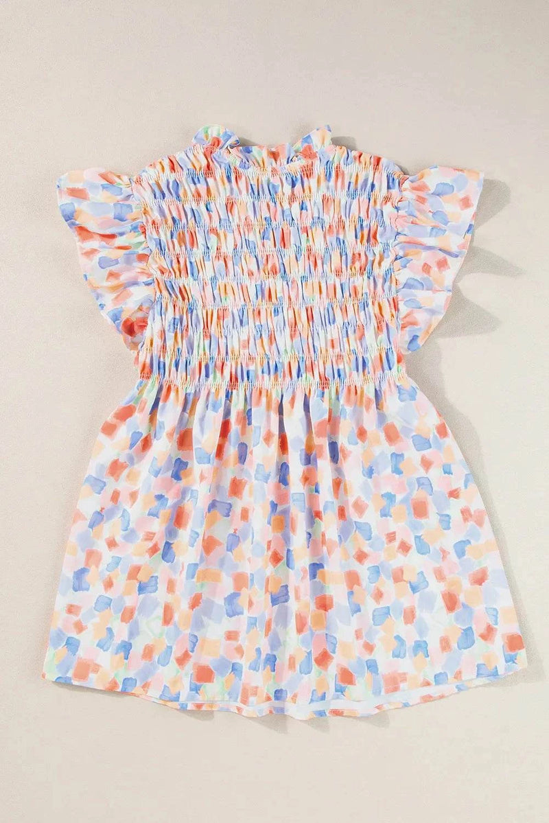 Ruffled printed notched cap sleeve blouse in colorful pattern.