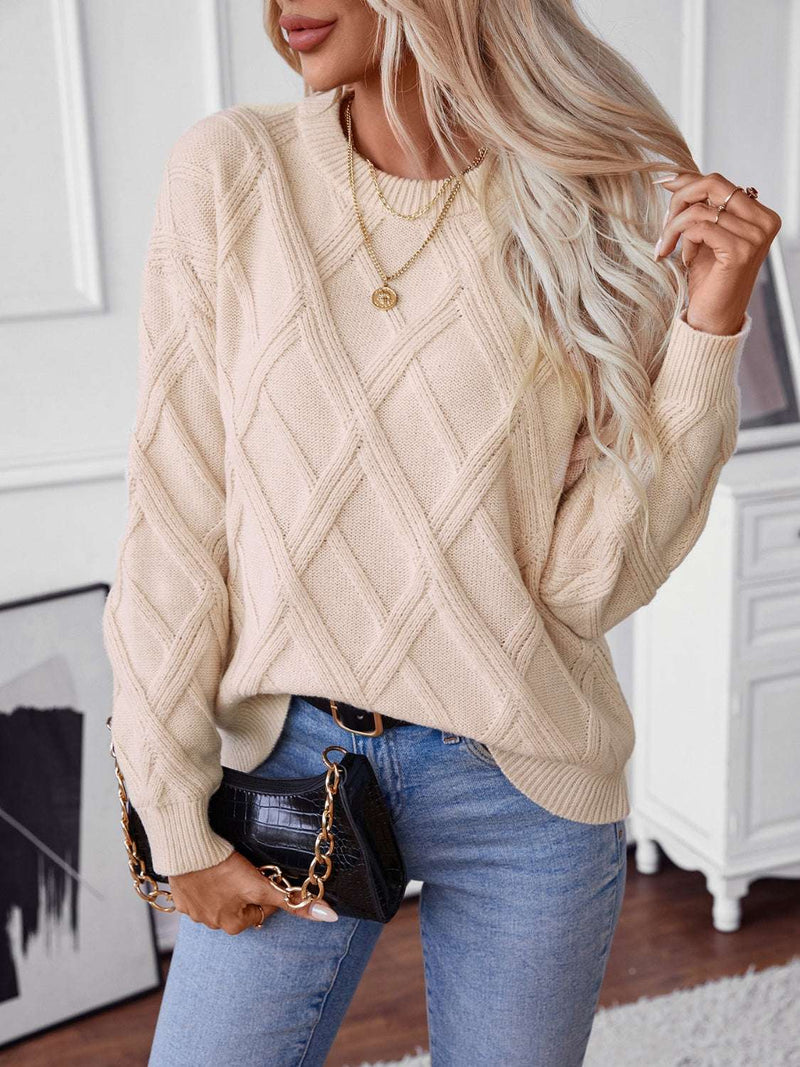 Cozy round neck sweater with geometric pattern and long sleeves, styled with jeans.