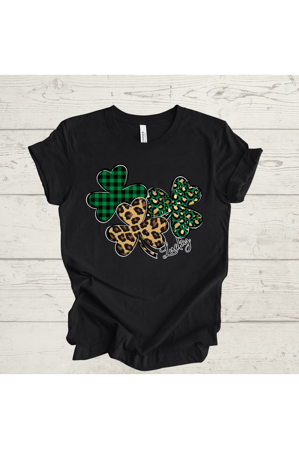 Clovers Tee with plaid, leopard, and polka dot designs on a black Bella Canvas CVC shirt.