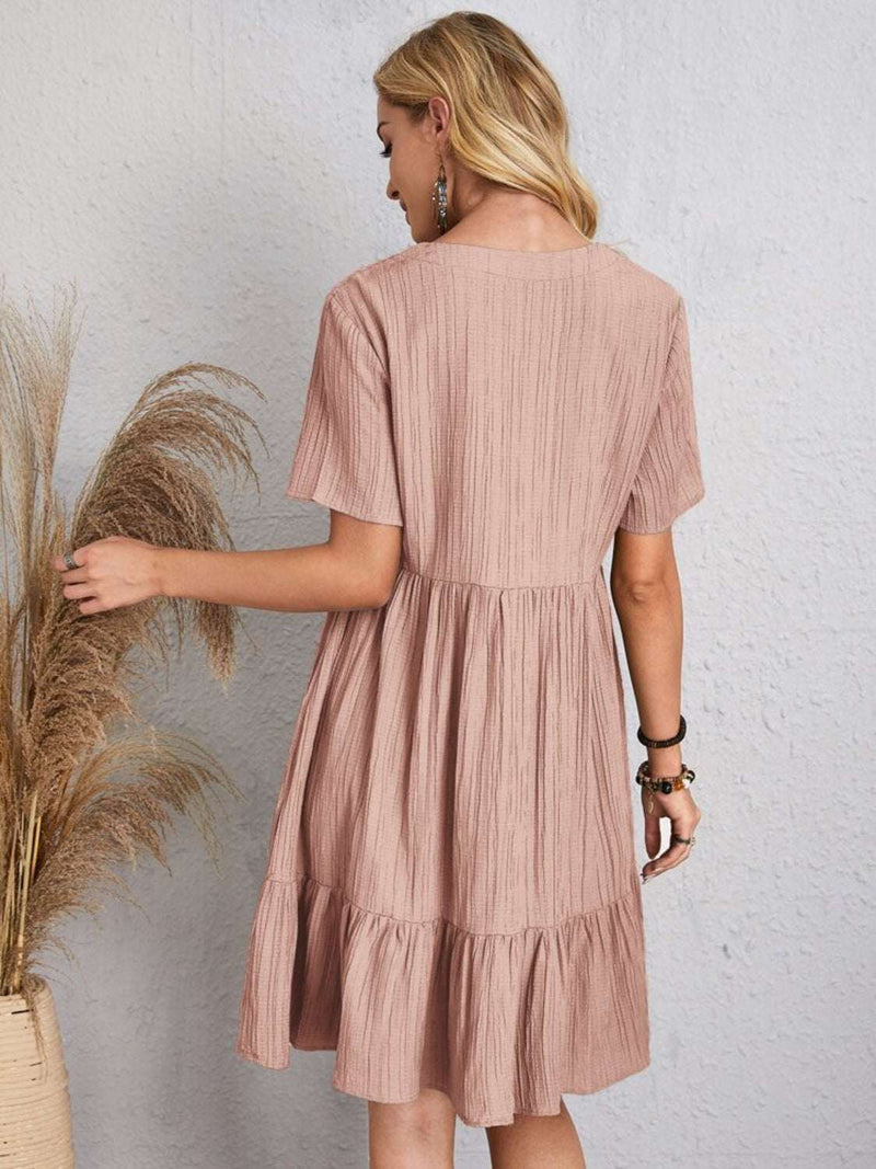 Full size V-neck short sleeve dress in light brown fabric, shown from the back.