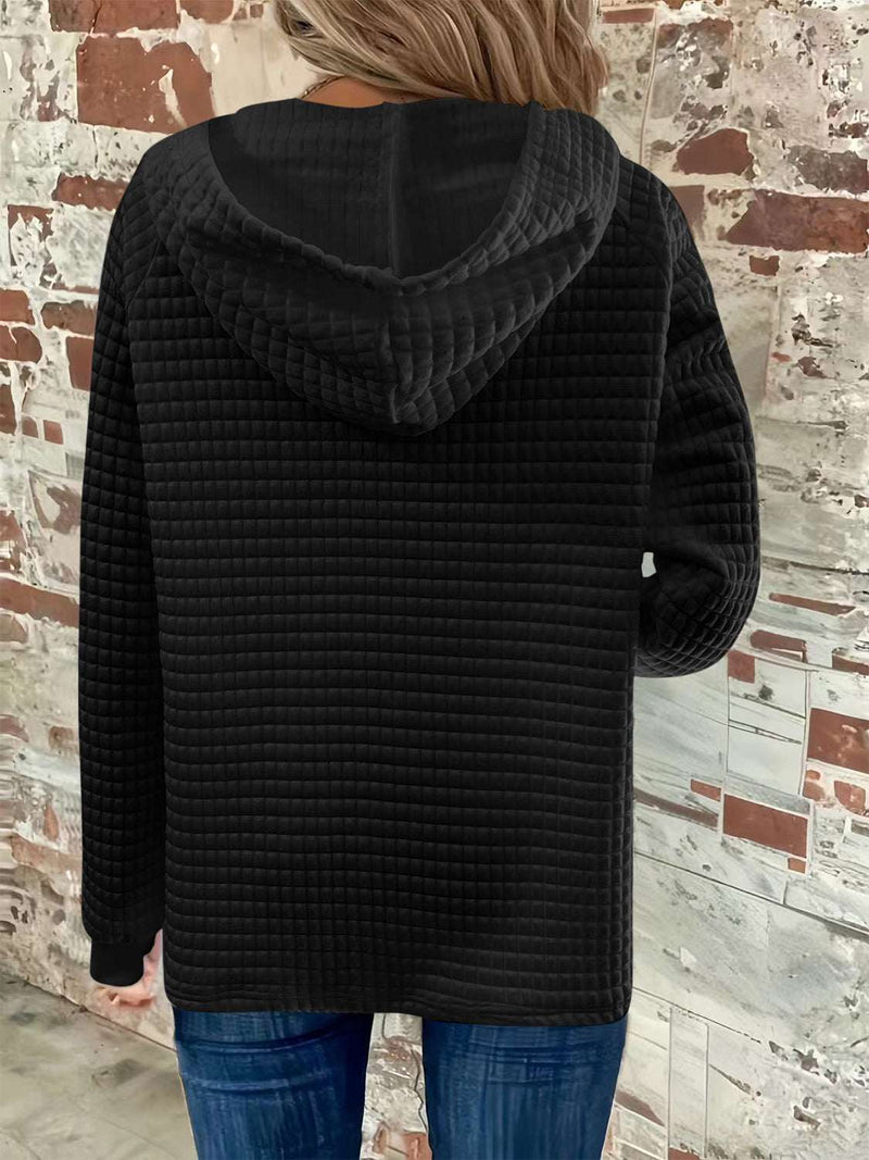 Full size black textured hoodie with button detail and drawstring, long sleeves, worn by person in jeans.
