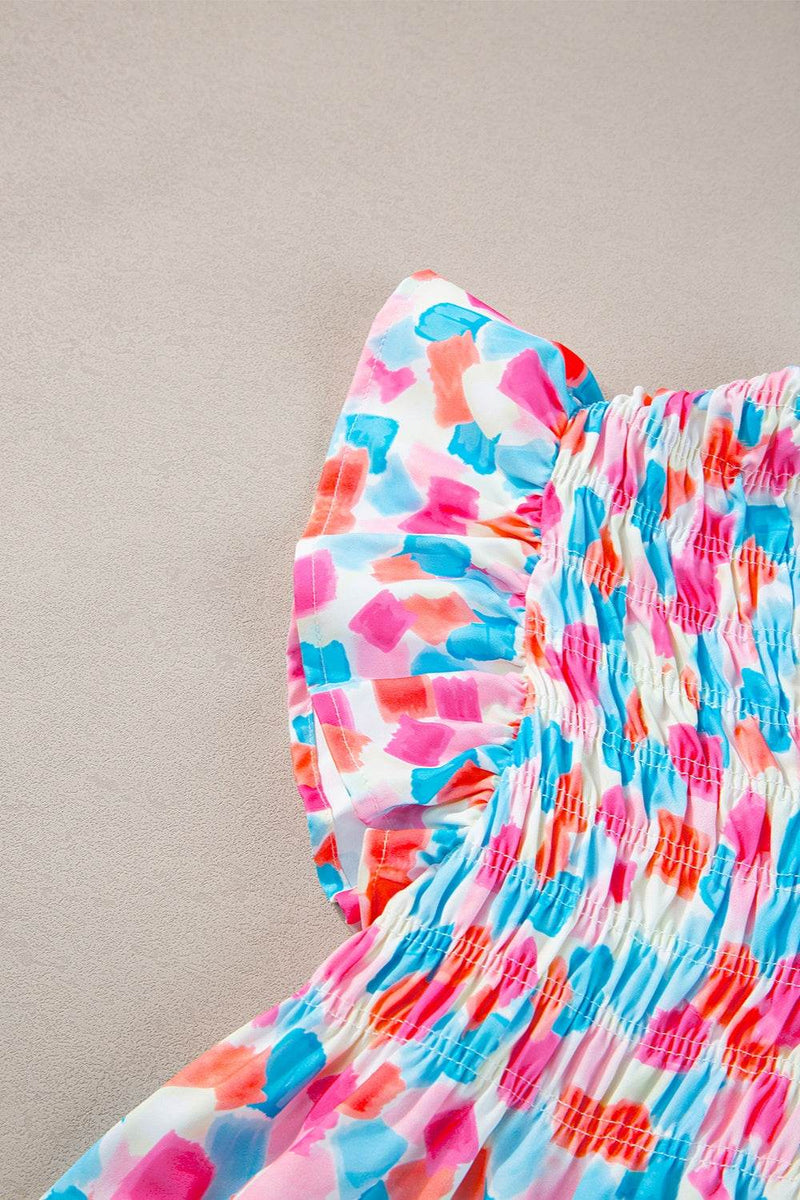 Ruffled printed notched cap sleeve blouse with colorful pattern.
