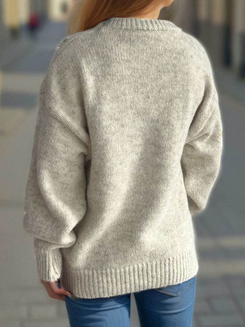 Round neck long sleeve sweater in soft fabric, worn by a person on a street.