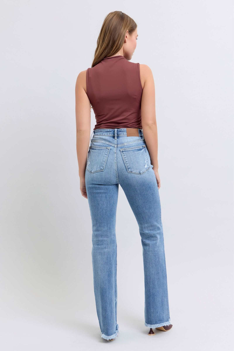 Judy Blue high rise bootcut jeans with raw hem, back view on model wearing brown top.