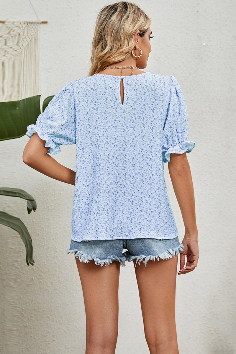 Round neck flounce sleeve blouse in light blue with floral pattern, rear view.