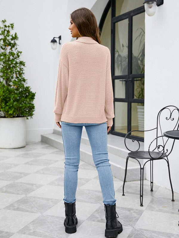 Woman wearing Turtleneck Dropped Shoulder Sweater, beige color, paired with jeans and black boots, standing outdoors.