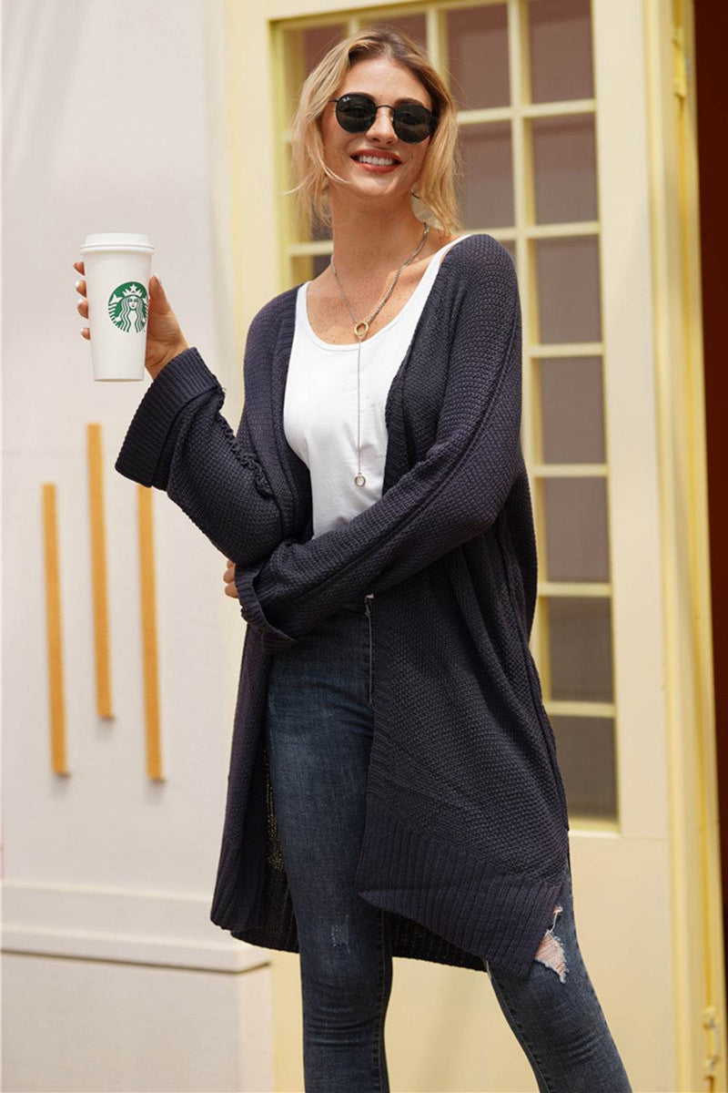 Woman wearing an open front long sleeve cardigan in casual outdoor setting.
