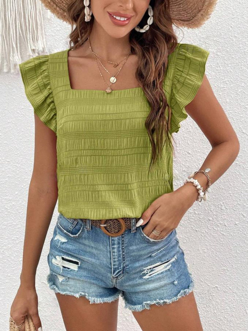Ruffled square neck cap sleeve blouse in green, paired with denim shorts.
