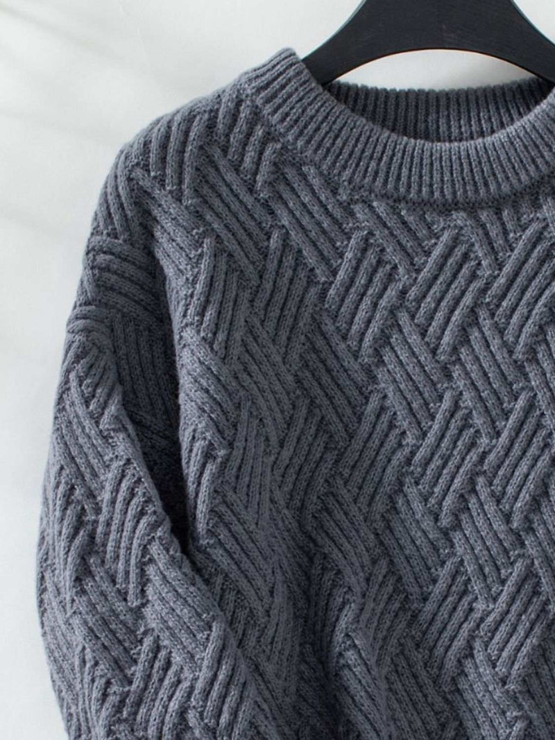 Round Neck Long Sleeve Woven Sweater in textured fabric hanging on a hanger.