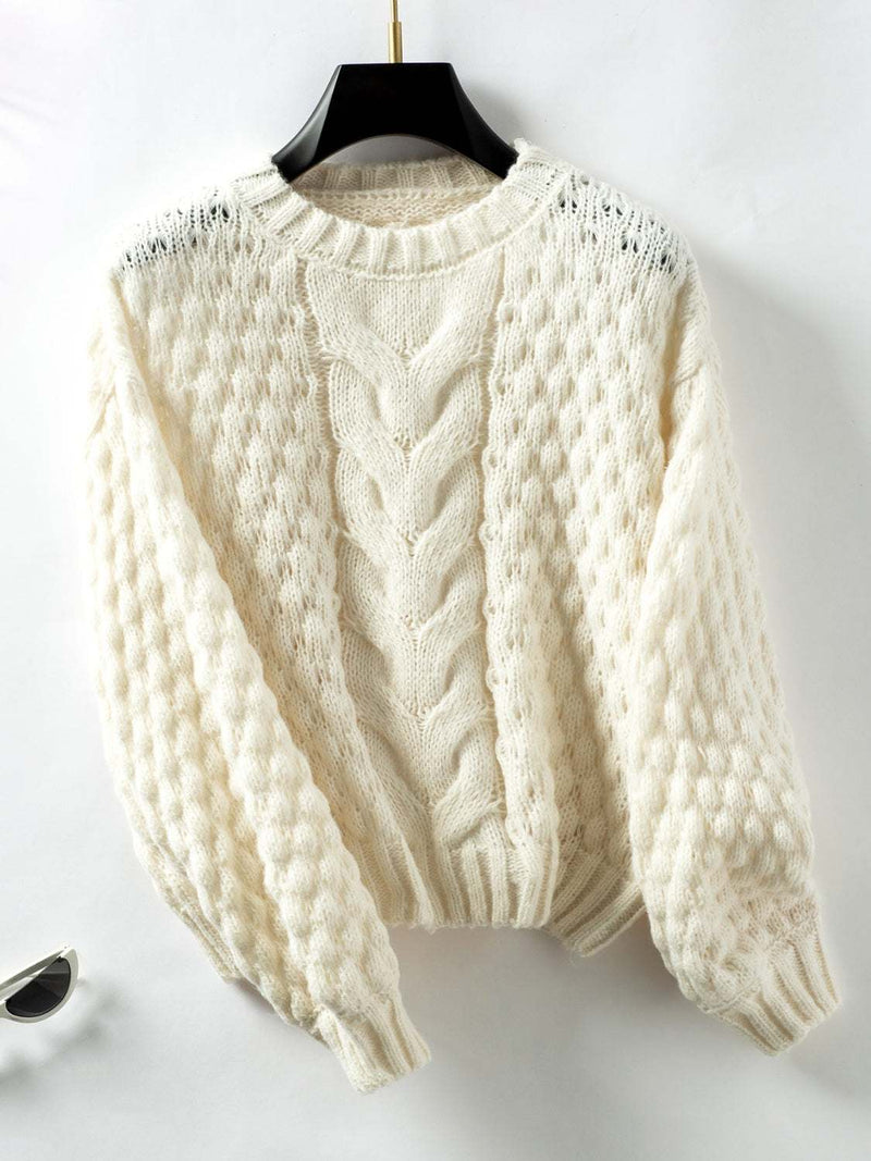 Cable-knit round neck long sleeve sweater in soft cream color.