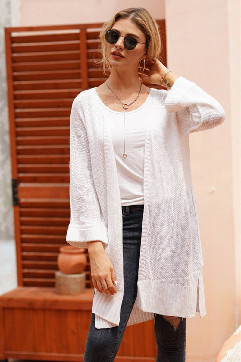 Woman wearing an open front long sleeve cardigan with basic style, slightly stretchy acrylic material.