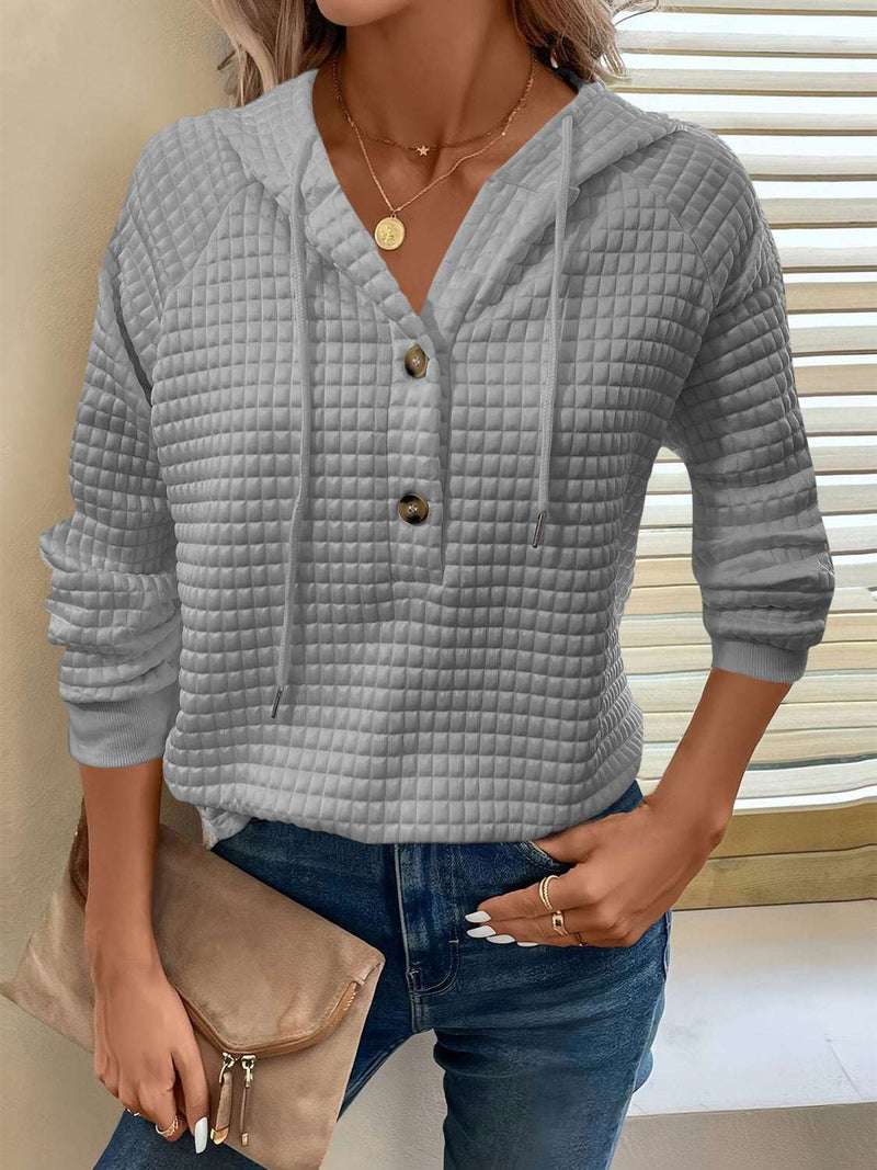 Full size texture button detail drawstring long sleeve hoodie with opaque material and no stretch.