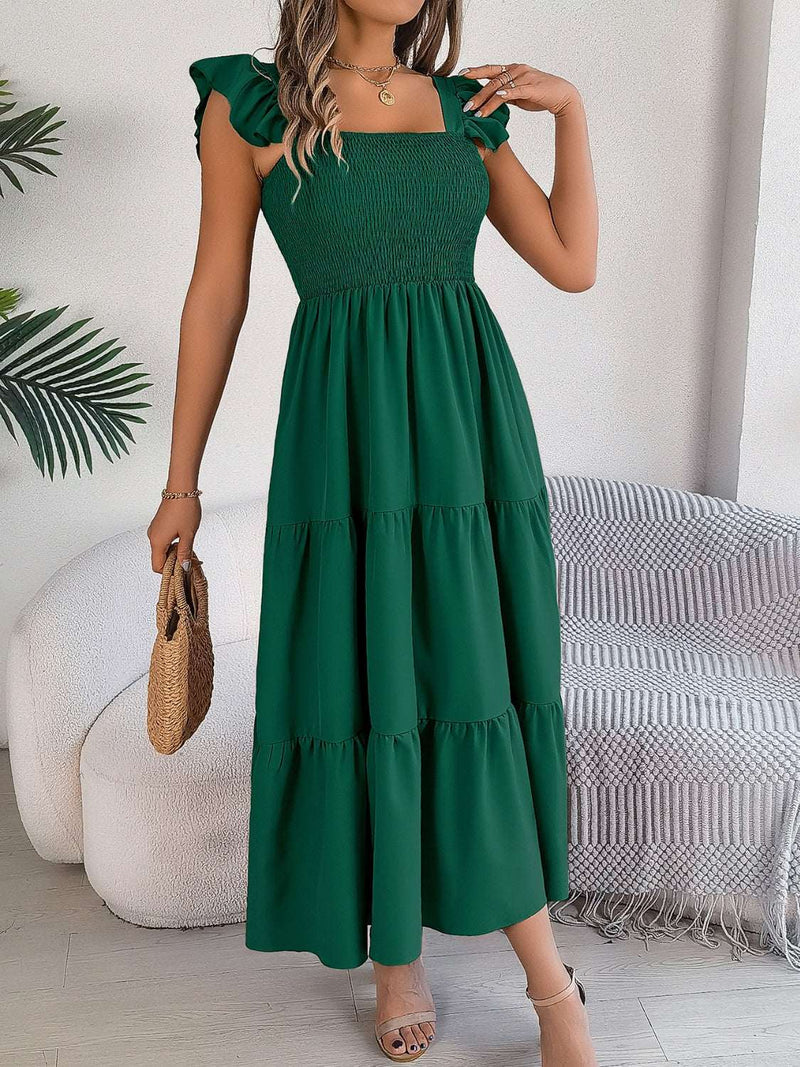 Green smocked square neck cap sleeve midi dress with tiered skirt displayed on model in indoor setting.
