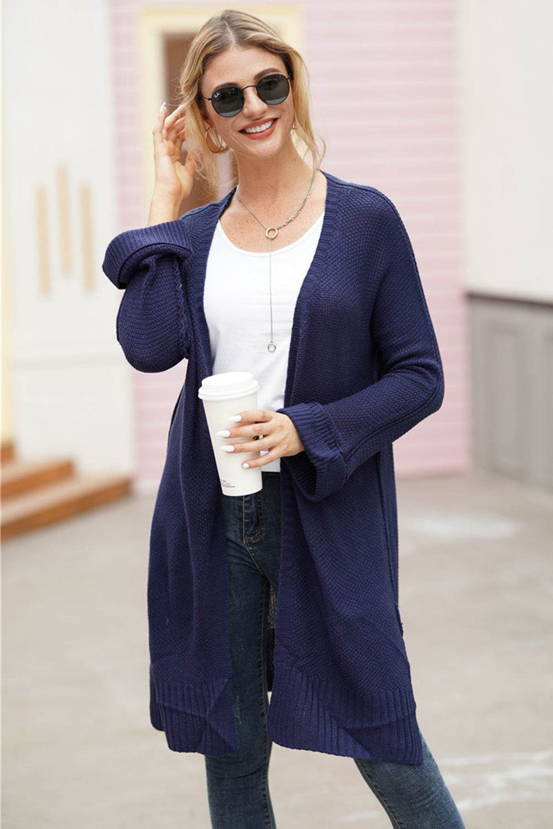 Woman wearing a navy open front long sleeve cardigan.