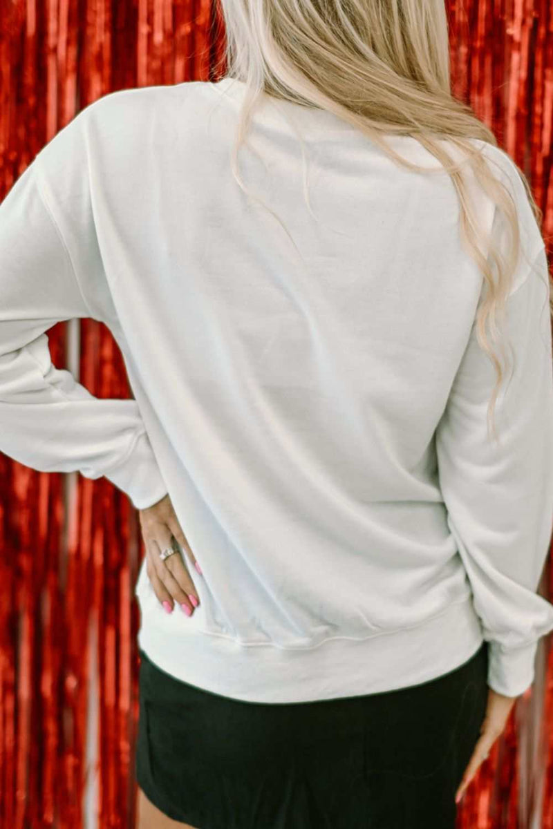 Valentine’s Day XOXO glitter round neck sweatshirt, back view with red backdrop.