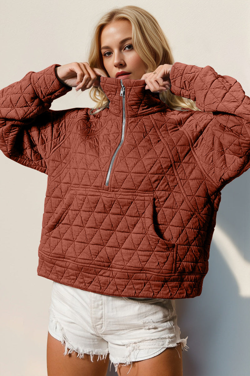 Half zip long sleeve quilted sweatshirt with pocket in rust color.