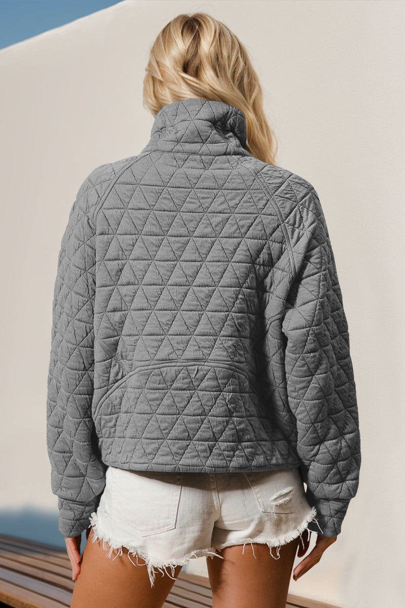 Gray quilted half zip long sleeve sweatshirt with pocket.