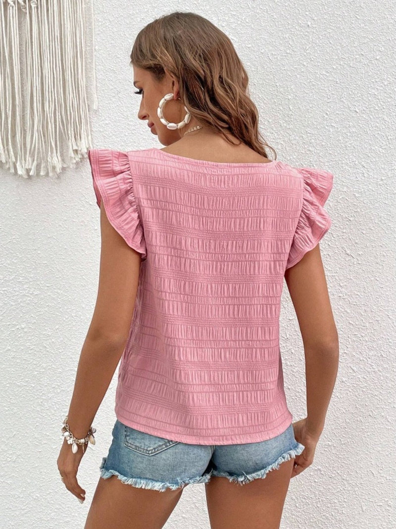 Ruffled square neck cap sleeve blouse in pink, worn with denim shorts.