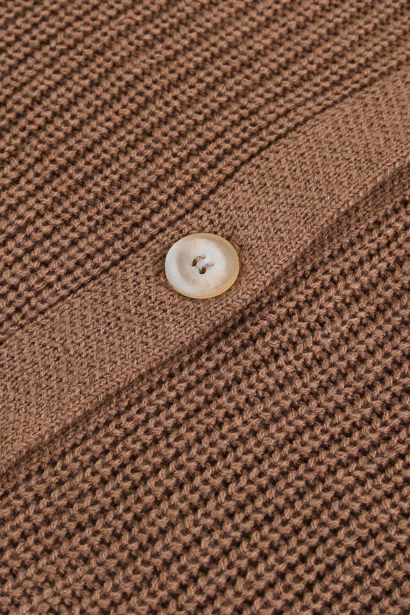 Close-up view of openwork V-neck button-up cardigan fabric and button detail.